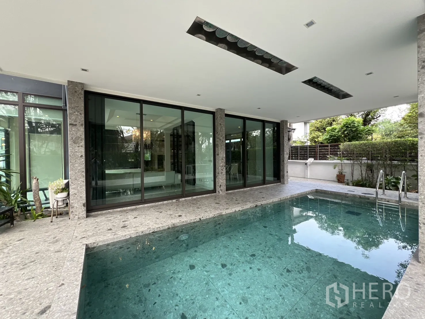 บ้านเดี่ยว for rent in Prawet, Bangkok - สระว่ายน้ำข้างผนังกระจกเต็มบาน มองเข้าไปยังพื้นที่นั่งเล่น