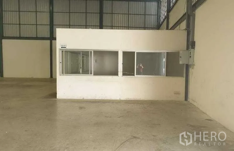 Warehouse for rent in Mueang Samut Prakan, Samut Prakan - Interior view of warehouse with a built-in office box featuring sliding windows.