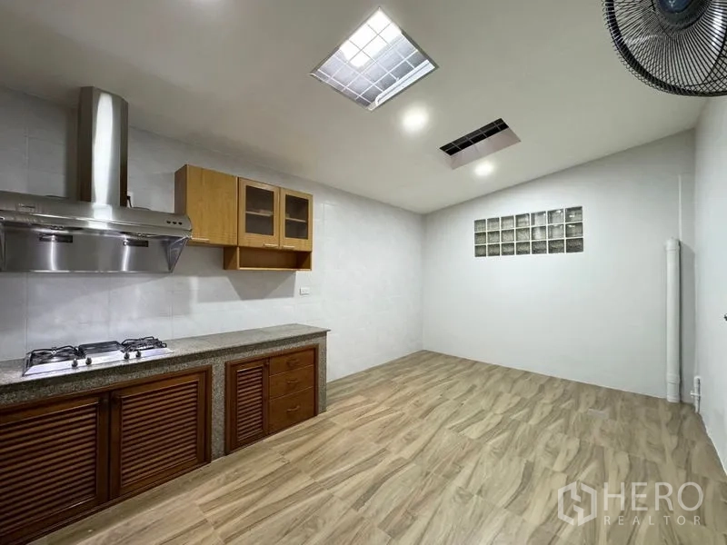 Townhouse for rent or sale in Suan Luang, Bangkok - Kitchen dining space with wood-look floor and wall glass blocks