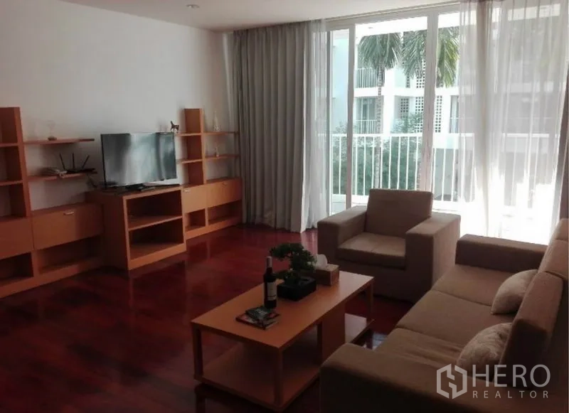 公寓 出租在Watthana, Bangkok - 客厅角度，电视与木质收纳柜，临阳台景。