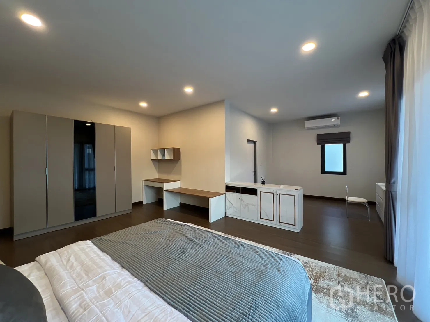 Detached House for rent or sale in Bang Phli, Samut Prakan - Wide view of master suite with wardrobe, desks and storage units.