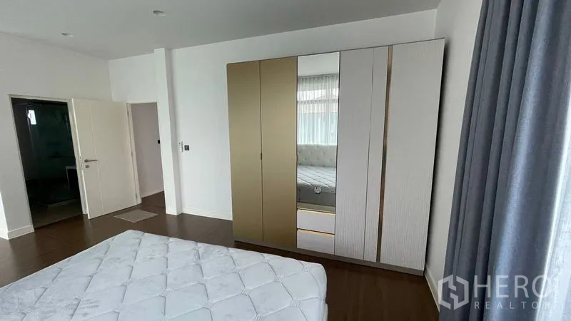 Detached House for rent in Bang Kapi, Bangkok - Master bedroom angle showing wardrobe and doorway to ensuite bathroom.