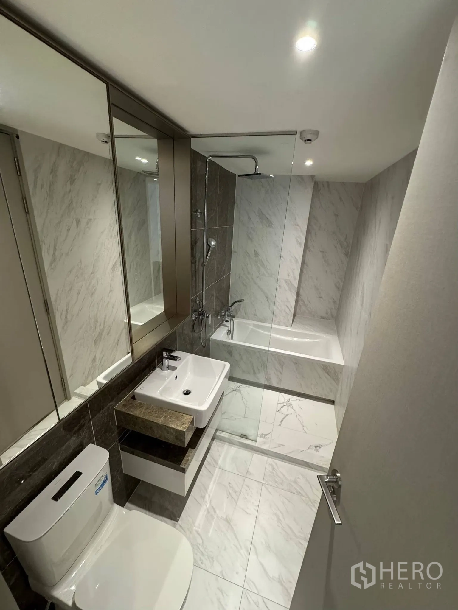 公寓 for rent in Khlong Toei, Bangkok - 现代浴室设浴缸与雨淋花洒、台盆与整面镜柜。