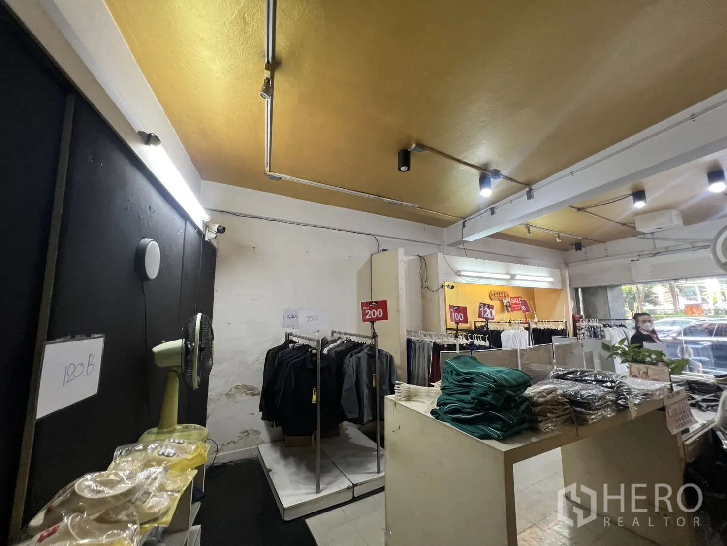 零售空间 出租在Khlong Toei, Bangkok - 店内销售区，衣架陈列与轨道射灯，临街窗户采光好。