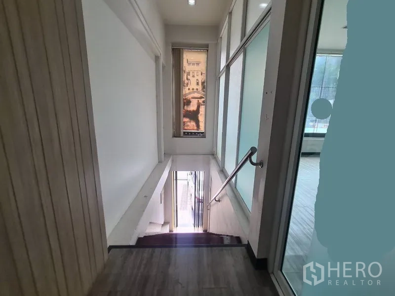 Retail Space for rent in Watthana, Bangkok - Interior landing with glass walls and stair access to street level.
