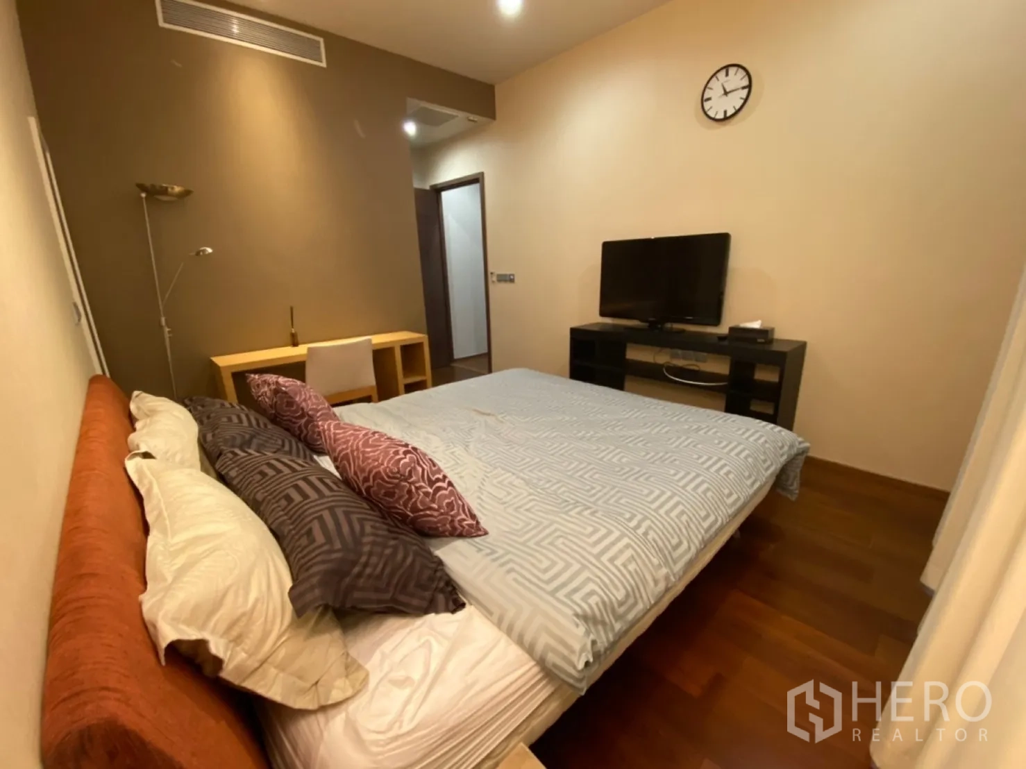 公寓 出租在Watthana, Bangkok - 主卧近景，床铺与抱枕、电视柜及书写桌。