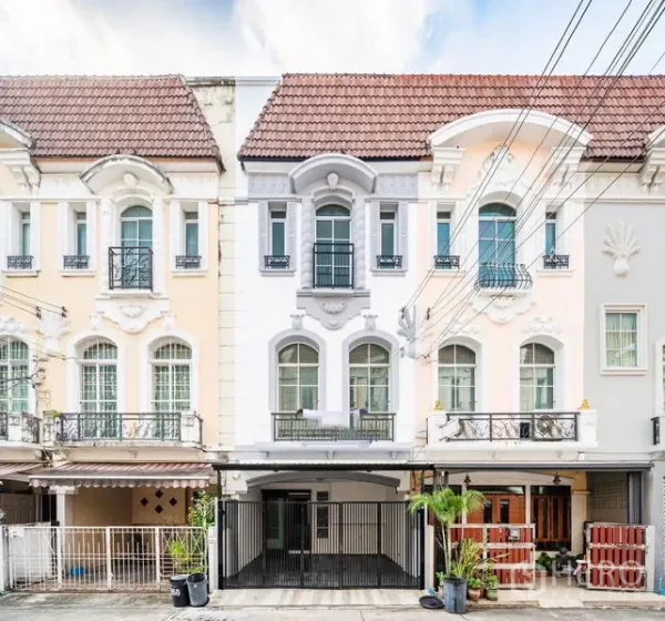 Townhouse for sale - Three-storey European-style townhouse façade with arched windows and balconies.