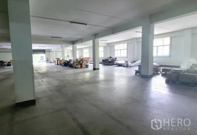 Factory for rent in Mueang Samut Prakan, Samut Prakan - Ground-floor storage and staging area with windows and stacked materials