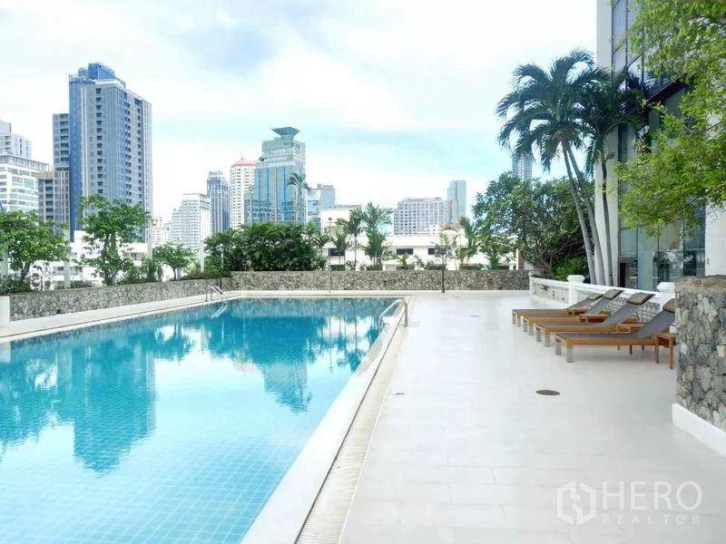 คอนโด ให้เช่าในWatthana, Bangkok - เด็คสระว่ายน้ำพร้อมเตียงนอนอาบแดด ต้นปาล์ม และวิวเมืองของคอนโด