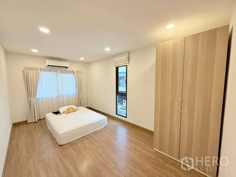 บ้าน ขายในBang Phli, Samut Prakan - ห้องนอนรองกว้างมีตู้เสื้อผ้า เครื่องปรับอากาศ และพื้นไม้