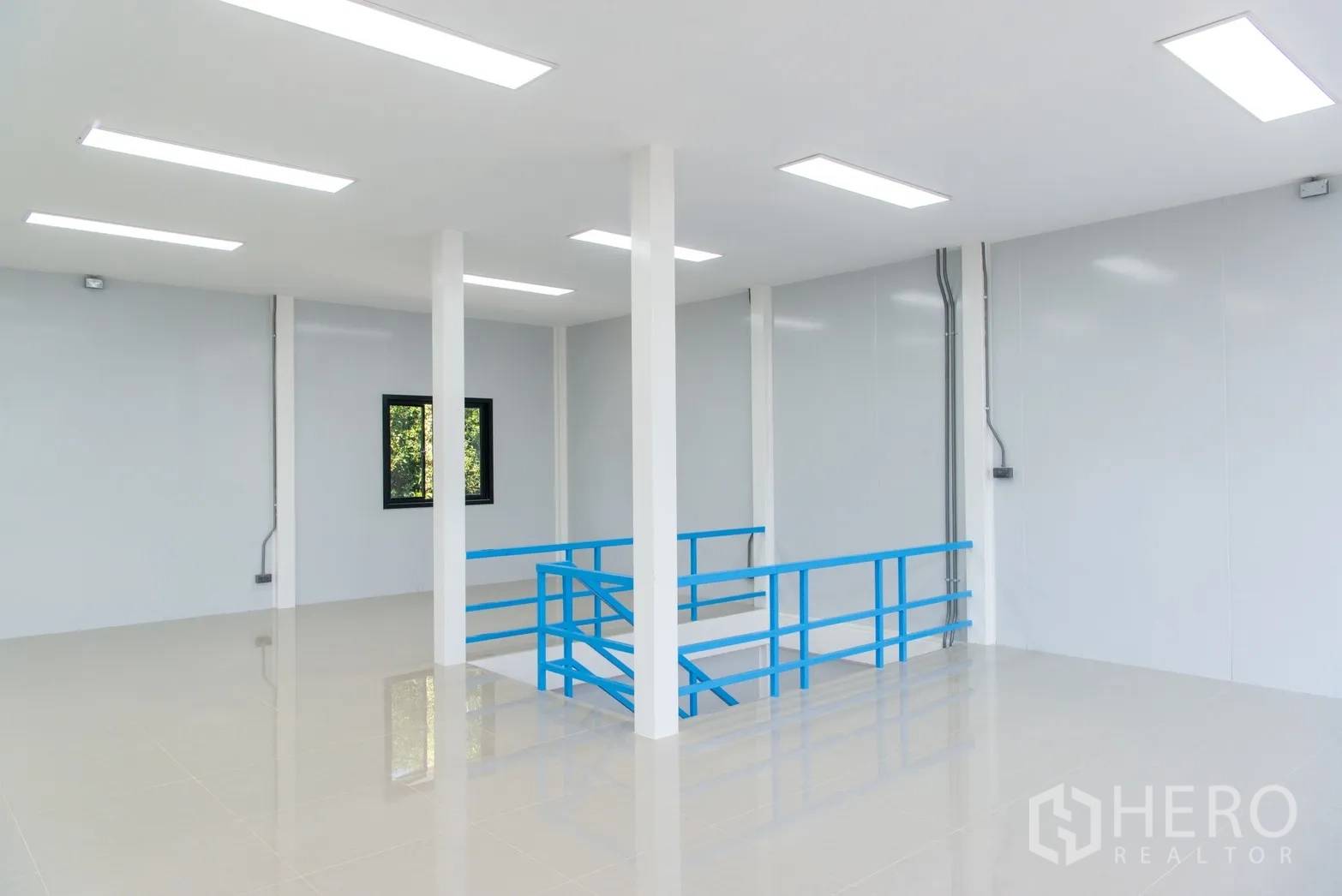 อาคาร standalone for rent or sale in Phra Khanong, Bangkok - ภายในสว่างโปร่ง โถงโล่ง เสาสีขาว และราวบันไดสีน้ำเงิน