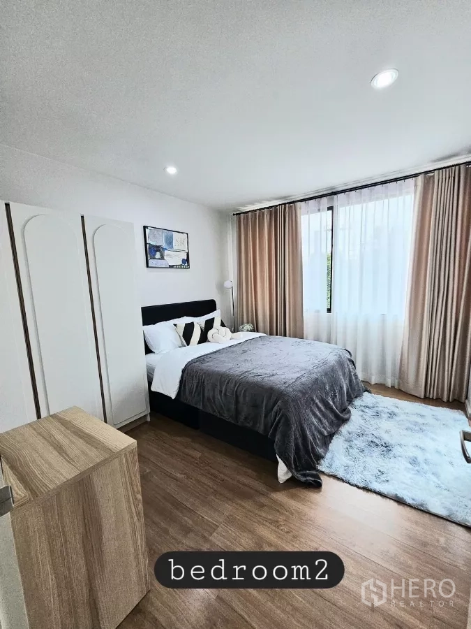 Townhouse for rent in Saphan Sung, Bangkok - Second bedroom with double bed, wardrobe and large window.