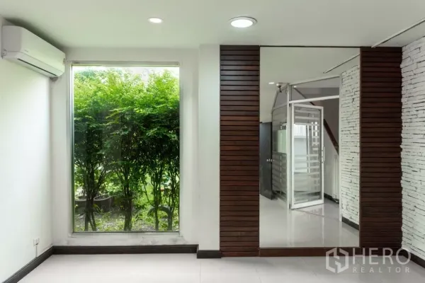 带办公室的家 出租在Lat Phrao, Bangkok - 房间配大幅落地窗，面向绿篱与木格栅墙面。