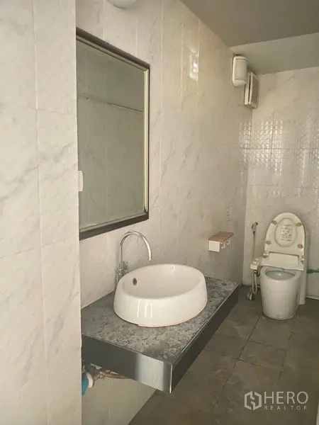 Retail Space for rent in Watthana, Bangkok - Tiled restroom with wall mirror, round basin and toilet inside the retail space.