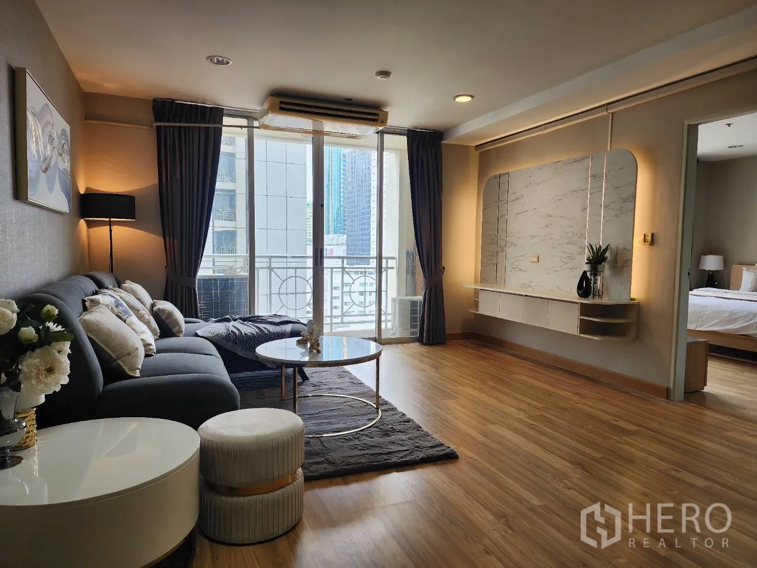 公寓 for rent in Watthana, Bangkok - 宽敞起居区连接阳台，并可见通往卧室的门口。