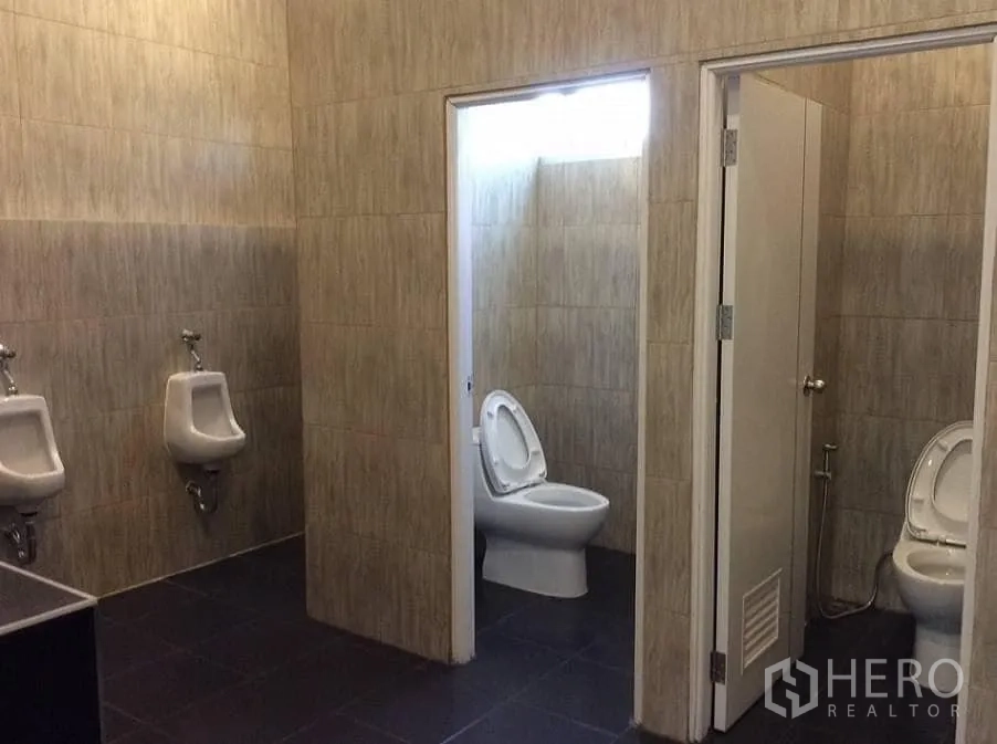 Factory for rent or sale in Bang Sao Thong, Samut Prakan - Clean tiled restrooms with toilets, urinals and partitions.