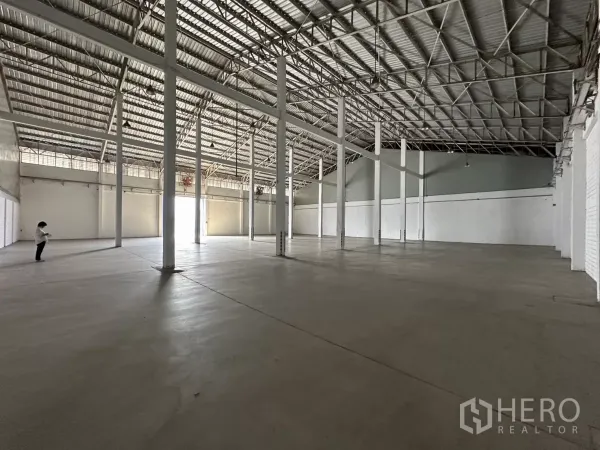Warehouse for rent in Phra Khanong, Bangkok - Wide open storage hall with steel truss roof and skylight panels, clear-span layout.