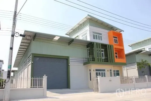 โรงงาน ให้เช่าหรือขายในLam Luk Ka, Pathum Thani - อาคารโรงงานสมัยใหม่พร้อมประตูม้วนขนาดใหญ่และอาคารสำนักงาน 2 ชั้น ด้านหน้ามีกำแพงรั้ว