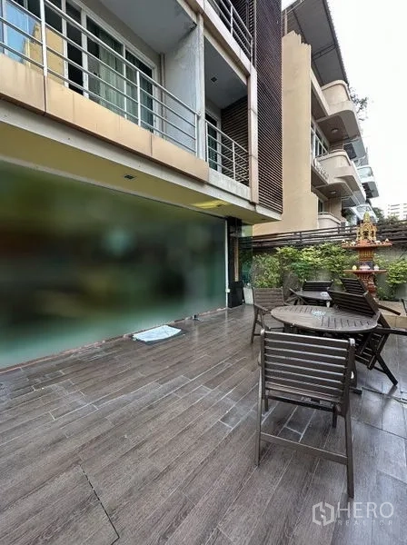 อพาร์ทเมนท์ ให้เช่าในKhlong Toei, Bangkok - ลานระเบียงชั้นล่างพร้อมโต๊ะเก้าอี้กลางแจ้งและต้นไม้ข้างอาคาร