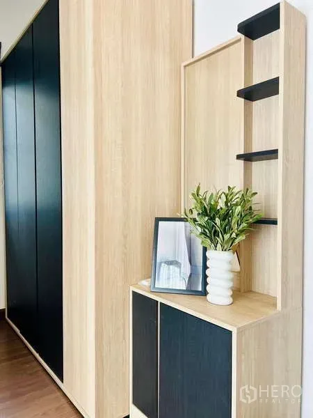 Detached House for rent in Bang Phli, Samut Prakan - Built-in wood wardrobe and vanity shelves with decorative plant and mirror.