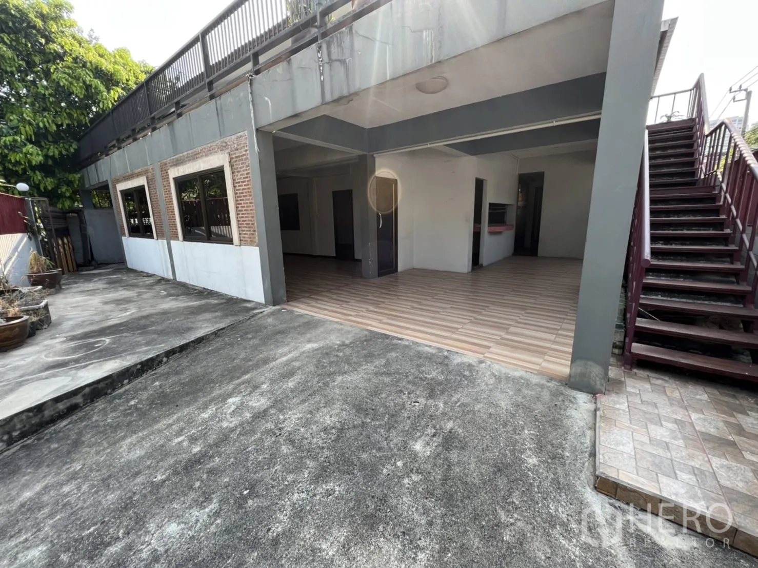 带办公室的家 出租在Watthana, Bangkok - 开放式车棚与一层空间，木纹地砖，旁侧楼梯通往二层。