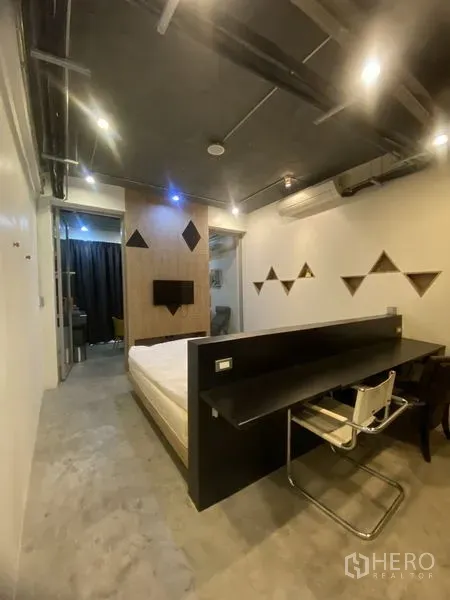 店屋 出租或出售在Khlong Toei, Bangkok - 紧凑卧室，长工作台、点缀照明与几何置物架。