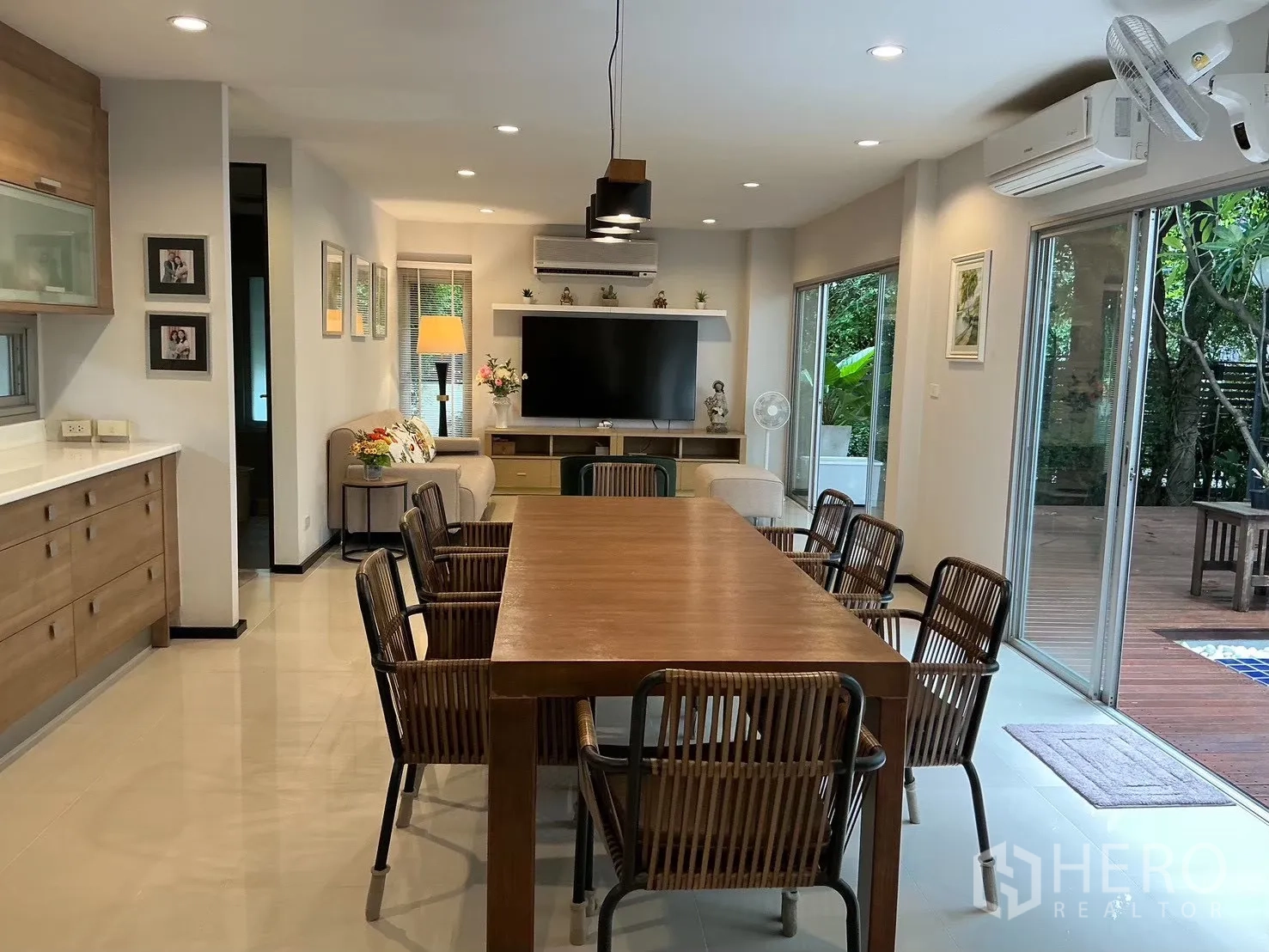 独栋房屋 for sale in Suan Luang, Bangkok - 开放式餐客区，长木餐桌和推拉落地窗。