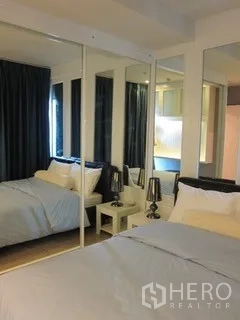 公寓 出租在Khlong Toei, Bangkok - 卧室温馨，带镜面衣柜、深色窗帘与床头灯。