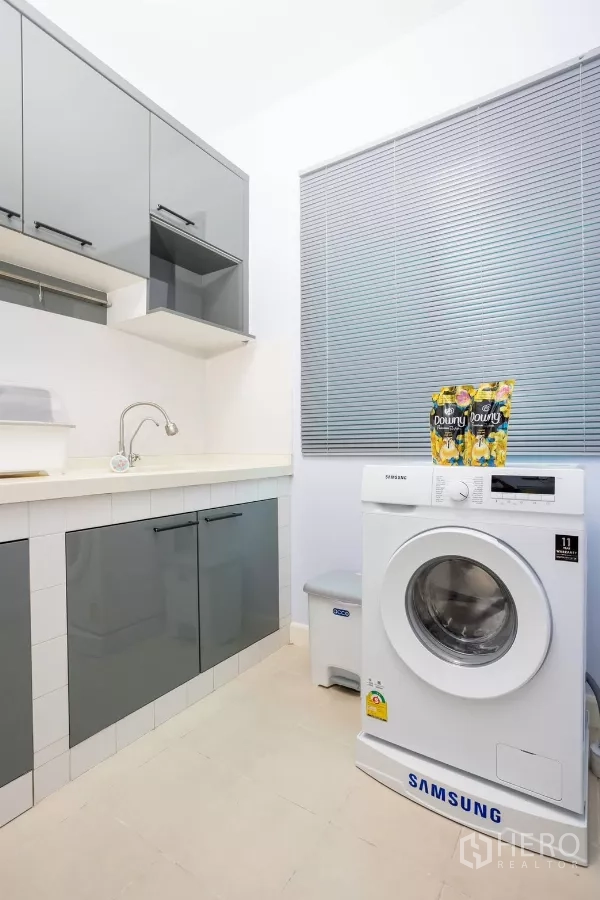 Townhouse for rent - Laundry and utility room with front-load washing machine, storage cabinets and blinds