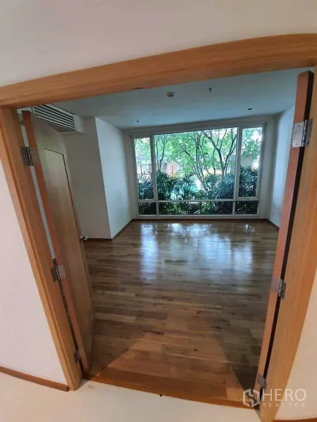 Condominium for rent or sale in Sathon, Bangkok - Bedroom with large picture windows overlooking lush garden landscaping.