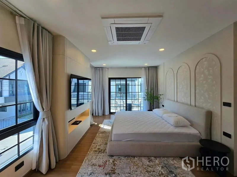 独立式住宅 出租在Bang Phli, Samut Prakan - 主卧面向落地推拉门与电视墙，大窗与吊顶空调。