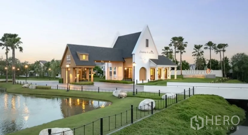 Townhouse for rent in Bang Phli, Samut Prakan - Community clubhouse by a pond with landscaped lawns at the project entrance.
