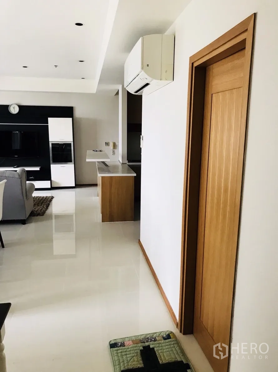 公寓 出租或出售在Khlong Toei, Bangkok - 开放式起居区，电视柜、厨房吧台与走廊，配壁挂空调。