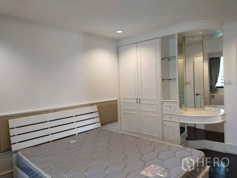 Condominium for rent in Sathon, Bangkok - Bedroom corner with built-in wardrobe and a mirrored dressing table.