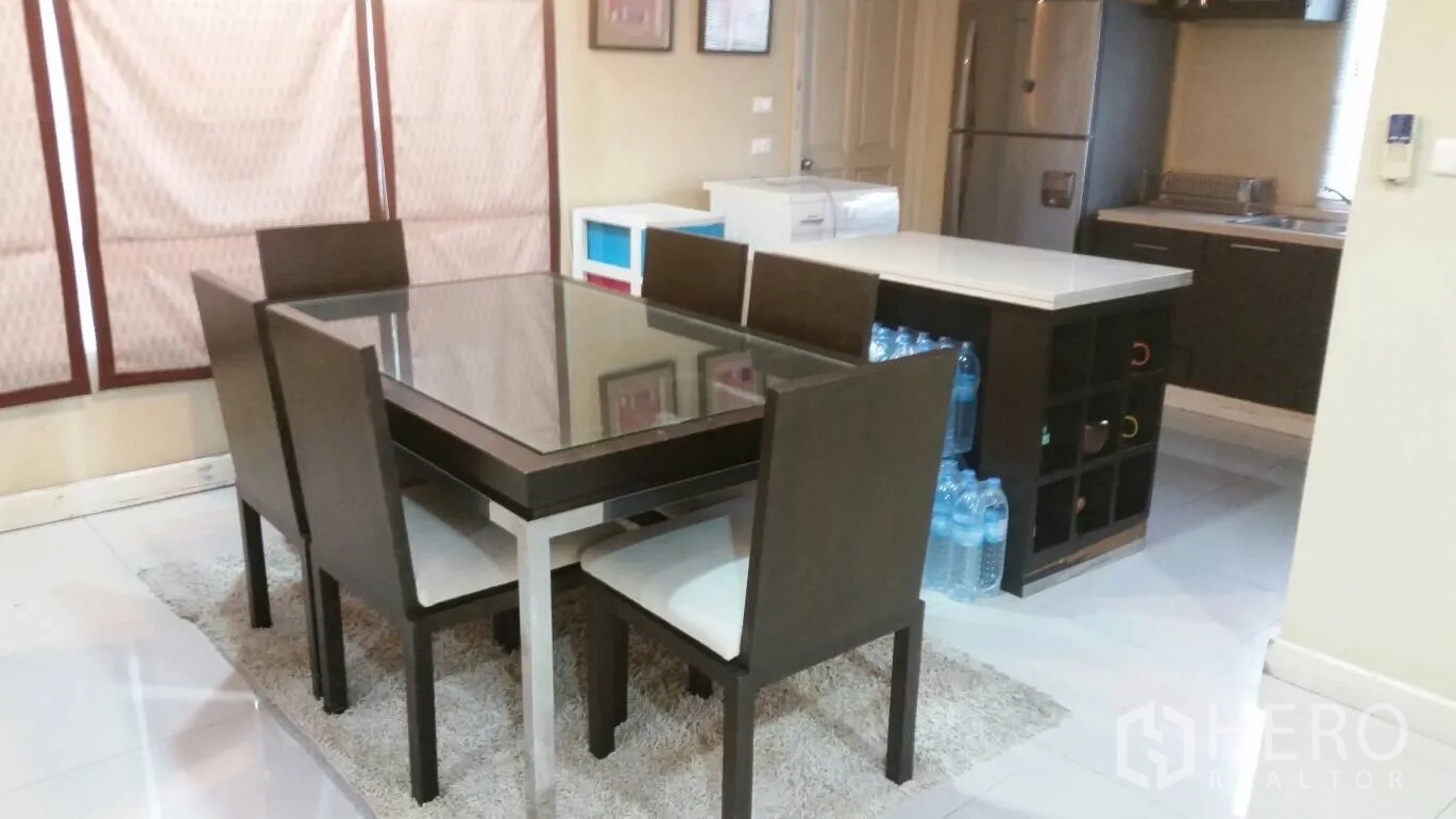 Detached House for rent in Lat Krabang, Bangkok - Dining table for six beside a kitchen island and stainless‑steel refrigerator.