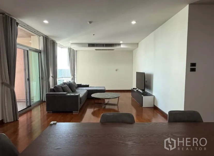 公寓 for rent in Pathum Wan, Bangkok - 客厅通过推拉玻璃门连接阳台，配窗帘。
