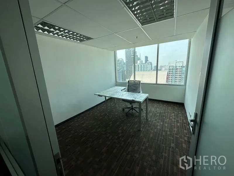 办公空间 出租在Watthana, Bangkok - 带大窗的角落办公室，L形办公桌与曼谷天际线景观。