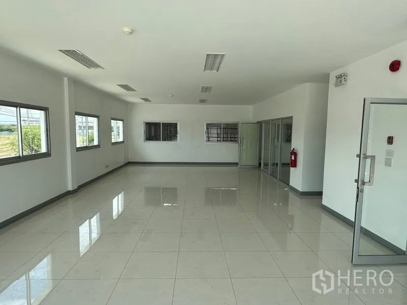 Factory for rent in Mueang Samut Prakan, Samut Prakan - Office area with multiple windows and sliding glass partitions for meeting rooms.