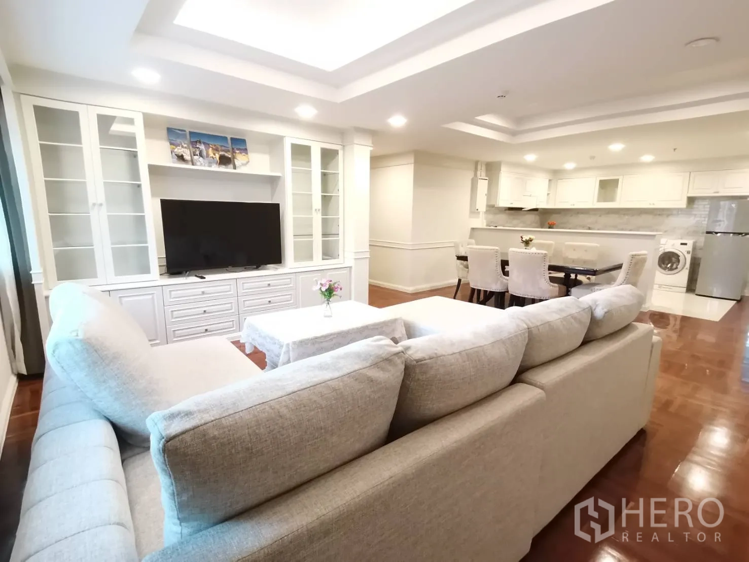 คอนโด for rent in Watthana, Bangkok - มองจากโซฟาไปยังชุดทานอาหาร ครัวเปิดพร้อมเครื่องใช้ ตู้ทีวีบิลท์อิน และพื้นไม้ขัดเงา