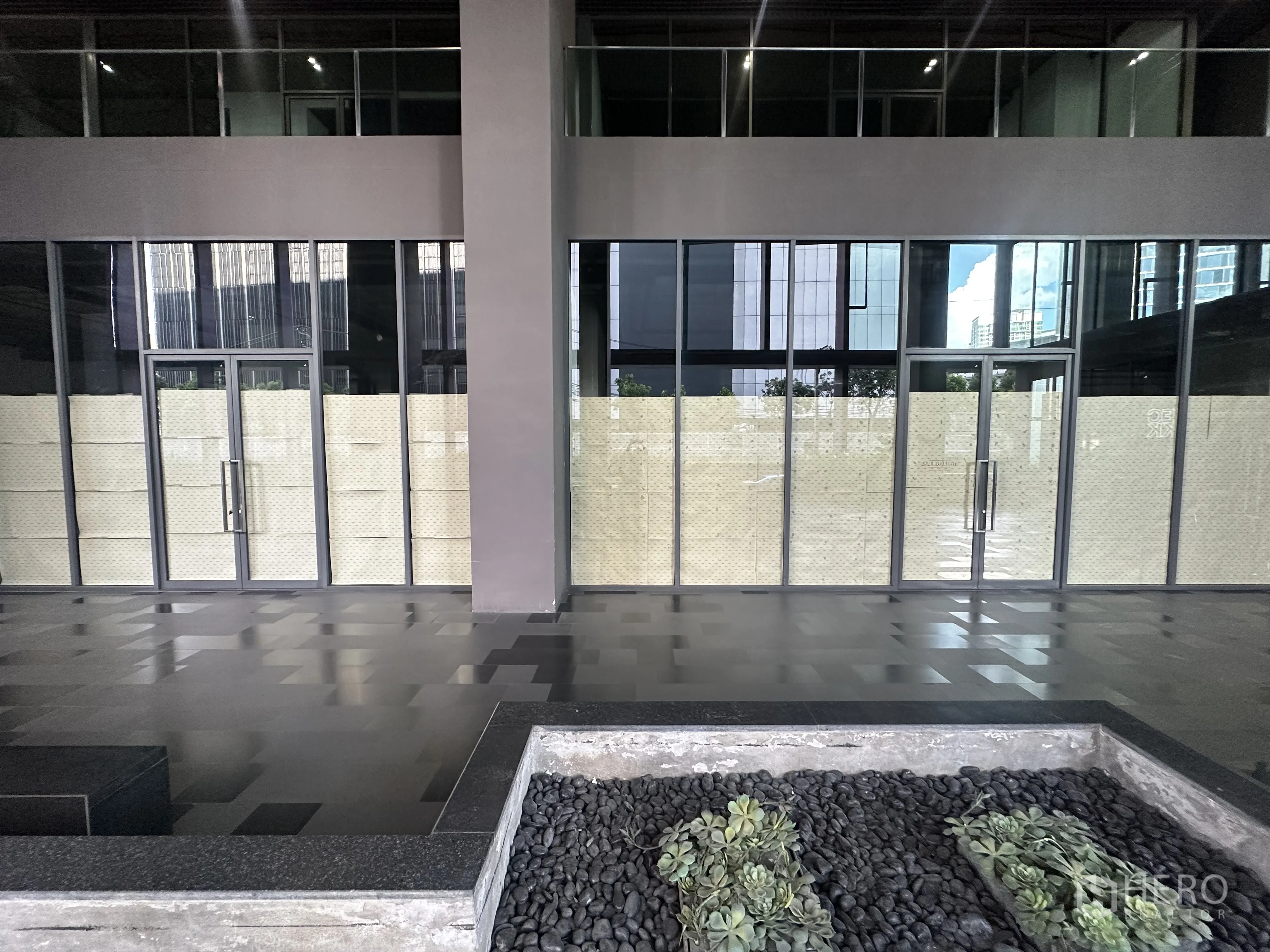 零售空间 for rent in Khlong Toei, Bangkok - 现代商铺立面，整面落地玻璃与双扇玻璃门，前方设景观花槽。