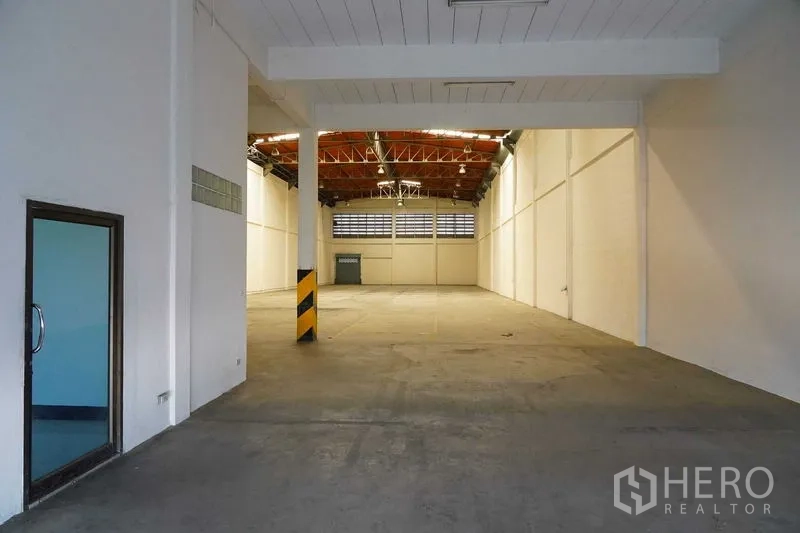 Factory for rent in Bang Sao Thong, Samut Prakan - Warehouse entrance showing open production space and safety‑marked columns.