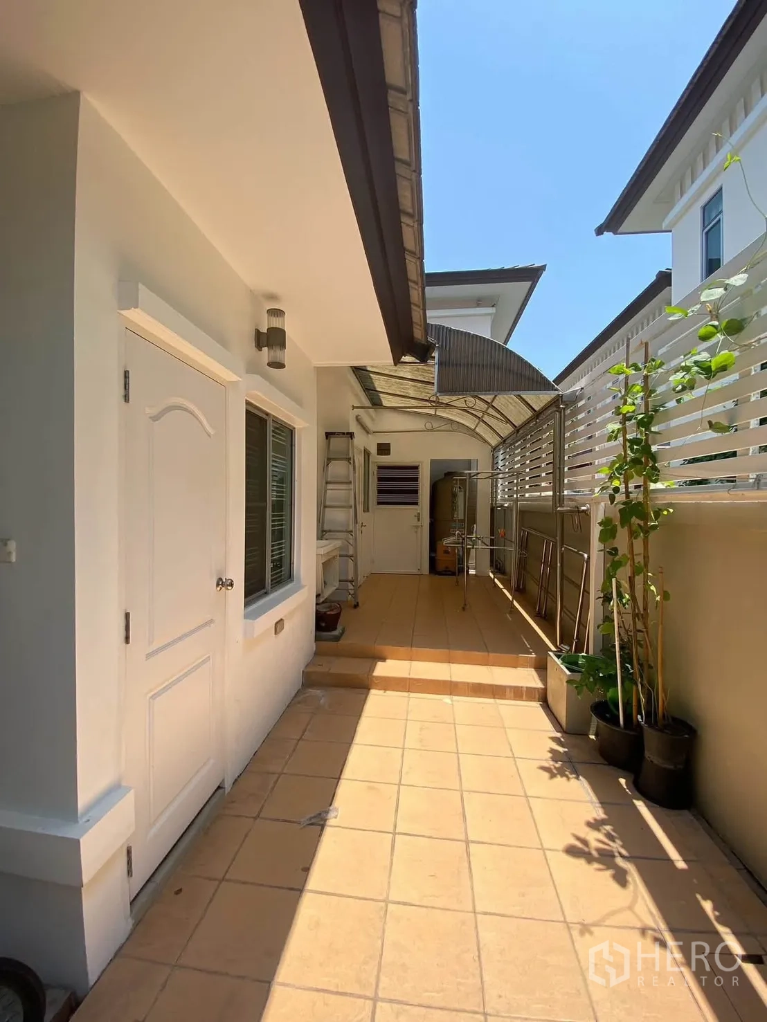 独栋房屋 for rent in Mueang Samut Prakan, Samut Prakan - 带棚侧走廊，铺砖地面与晾晒架。