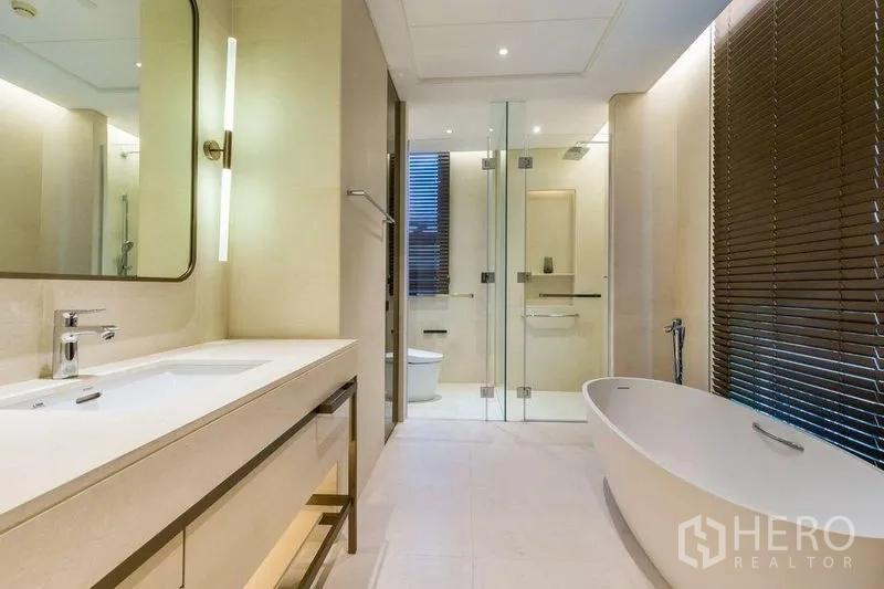 Condominium for rent in Pathum Wan, Bangkok - Luxury bathroom featuring a freestanding bathtub, double vanity, and glass-enclosed shower.