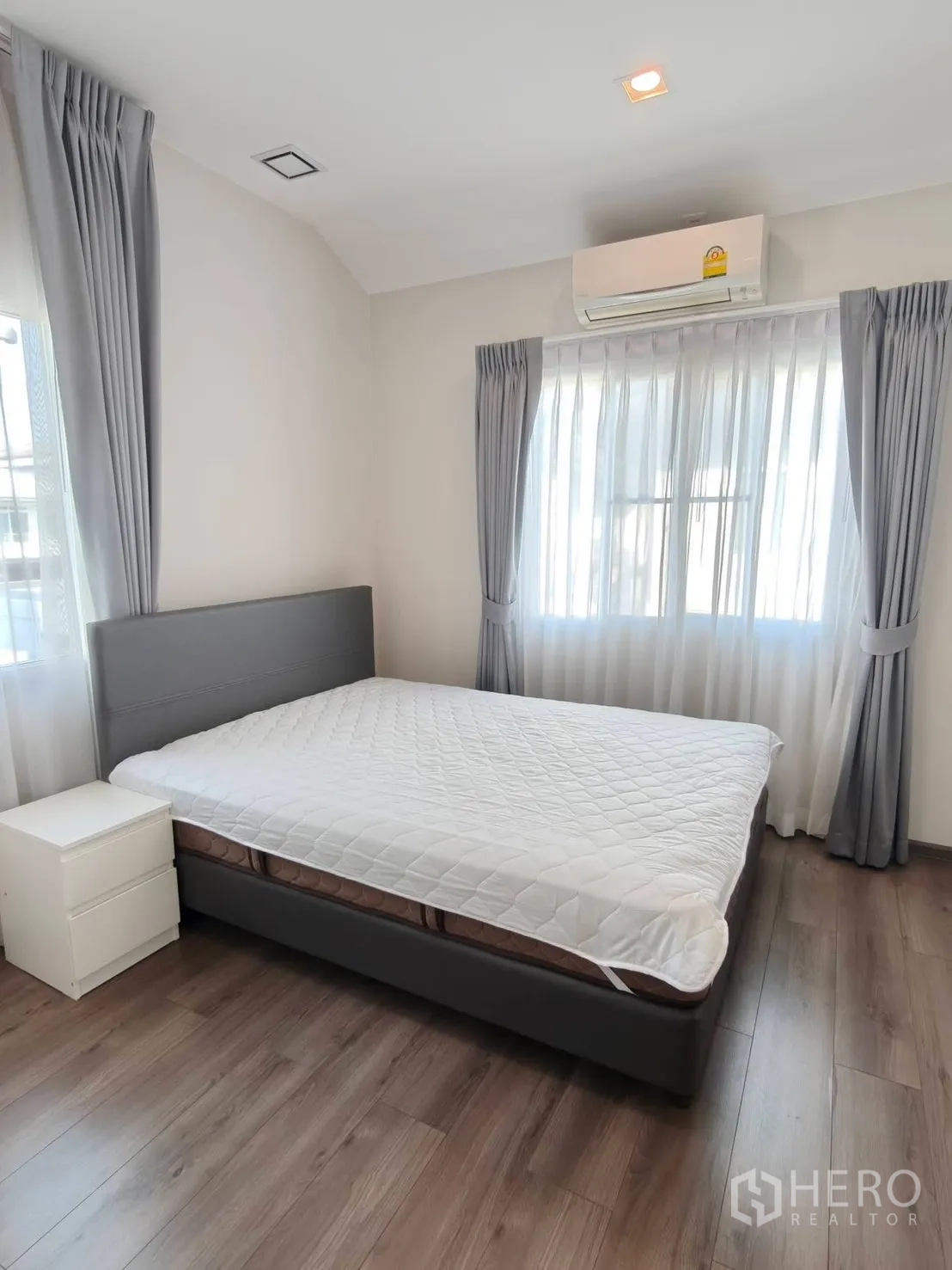 บ้านเดี่ยว for rent or sale in Bang Phli, Samut Prakan - ห้องนอนสว่างเตียงบุนวม เครื่องปรับอากาศ และพื้นไม้ลามิเนต.