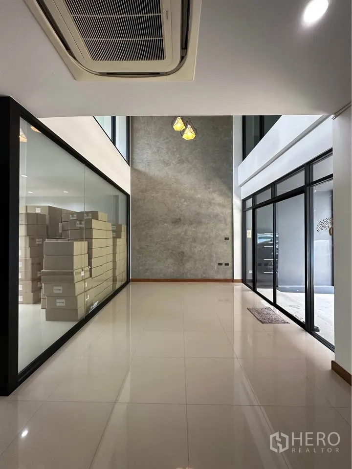 联排别墅 出租在Pak Kret, Nonthaburi - 明亮挑高入口大厅，亮面瓷砖地、玻璃隔间与吊顶空调。