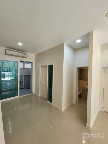 联排别墅 出租在Wang Thonglang, Bangkok - 明亮起居区，空调，推拉门通向半户外空间，旁边为卫生间。