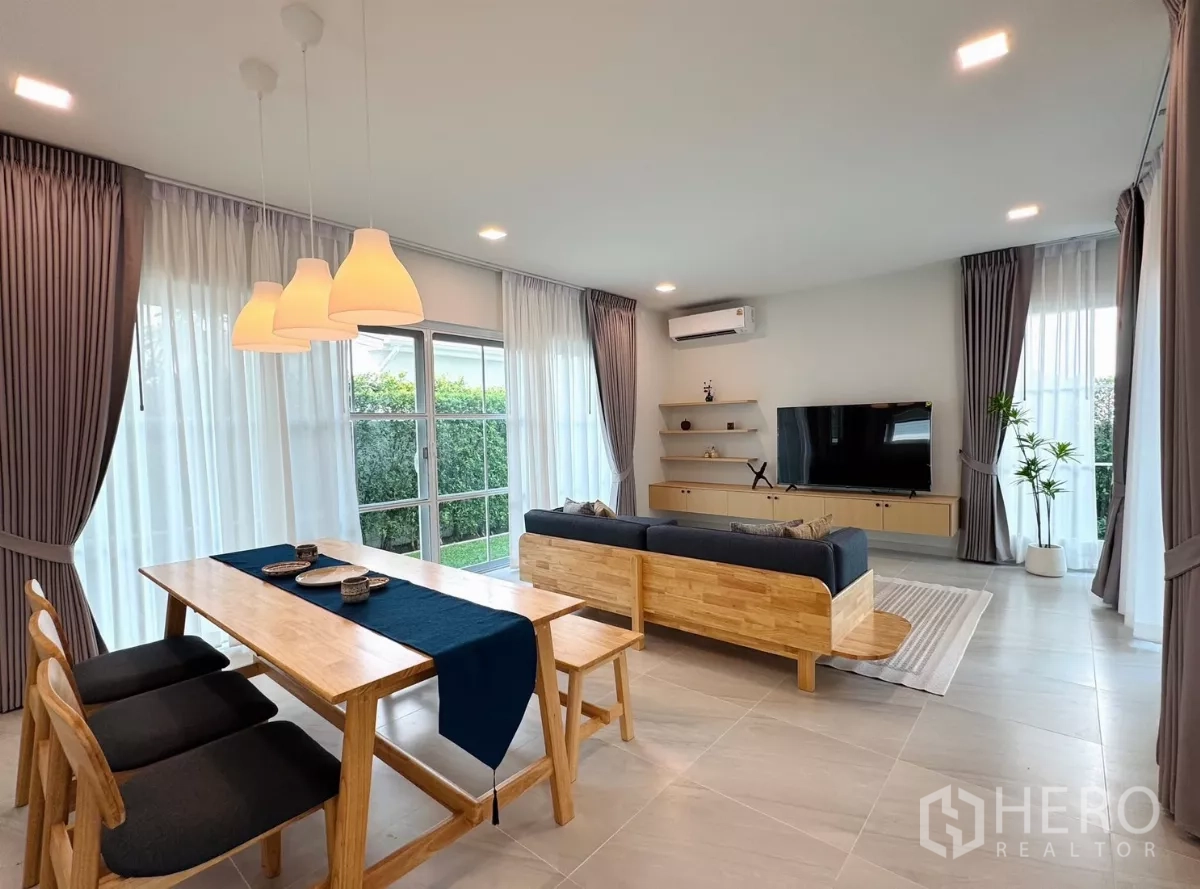 独立式住宅 出租在Bang Phli, Samut Prakan - 开放式客餐厅，大落地窗、纱帘与原木家具