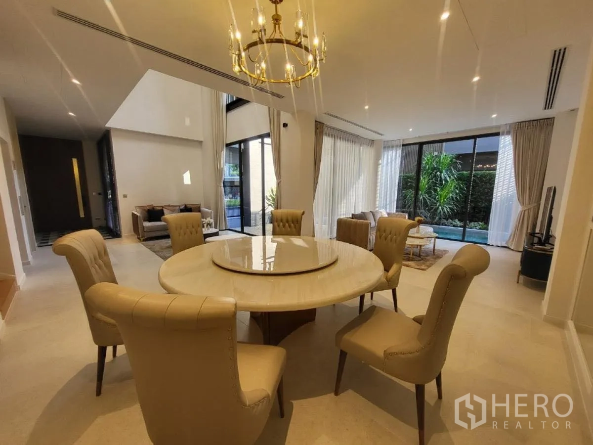 Detached House for rent in Wang Thonglang, Bangkok - Elegant dining area with chandelier and round table facing the garden pool.