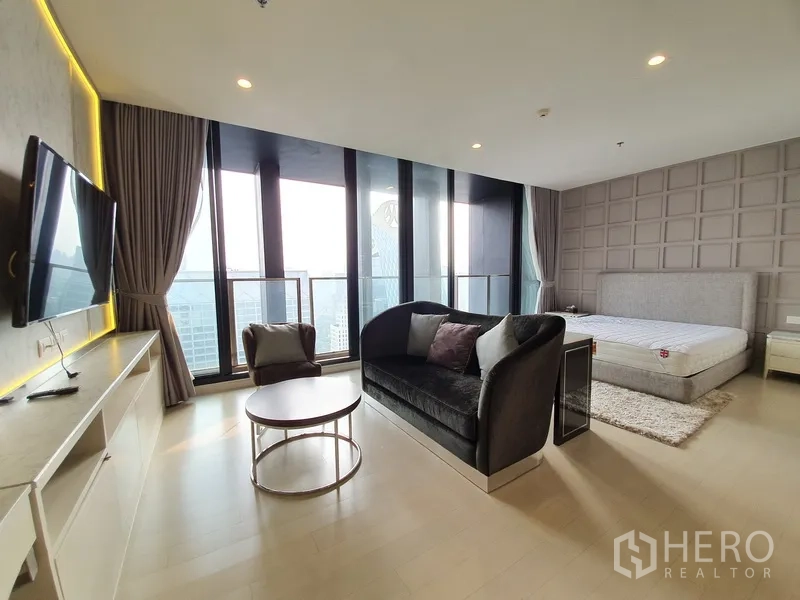 คอนโด ให้เช่าในPathum Wan, Bangkok - ห้องนอนมาสเตอร์กว้างพร้อมมุมนั่งเล่น กระจกเต็มผนังและระเบียงเห็นวิวเมือง