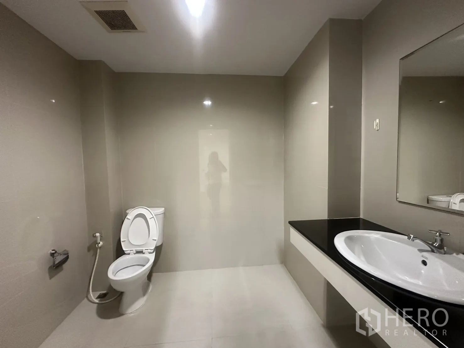 Office Space for rent in Watthana, Bangkok - Modern bathroom with toilet, large countertop sink, and wall mirror.